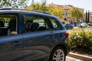 Zaprt avtomobil na poletnem soncu kot opozorilo pred puščanjem otrok in živali v vročem vozilu.